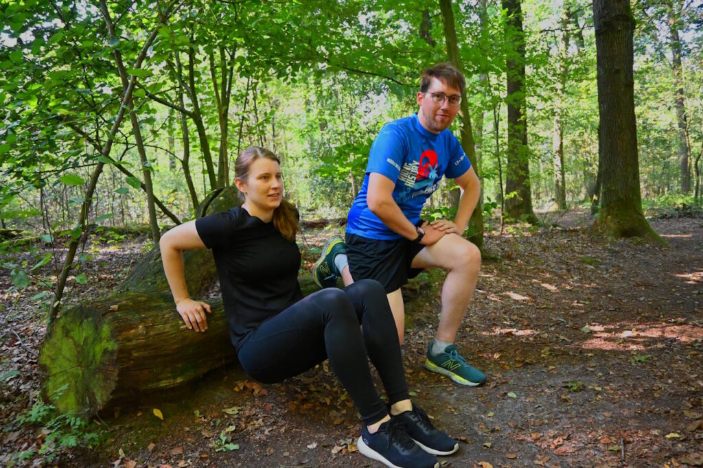 Simone und ein Trainingspartner führen gemeinsam eine Übung im Wald aus.