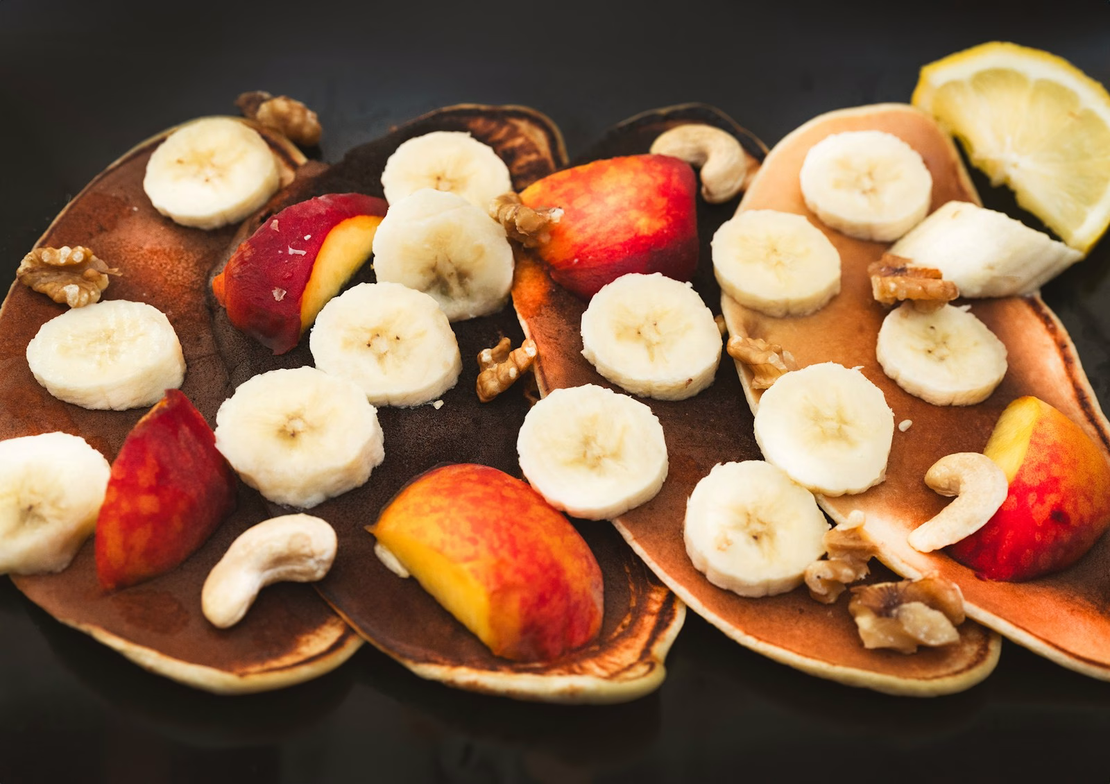 A close up of a plate of food with bananas and apples
